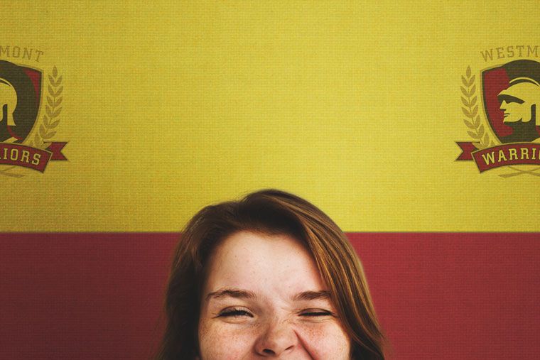 girl winking with custom printed fabric graphics of school logo behind her