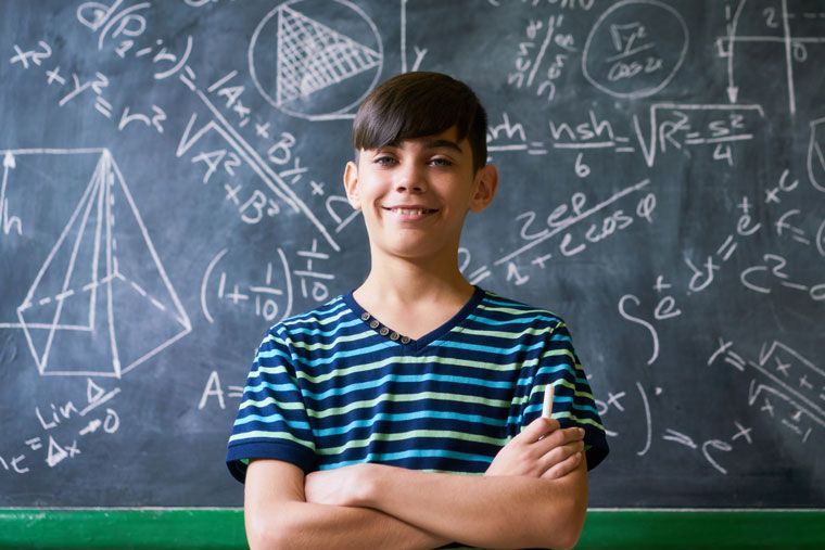 confident boy stands in front of complicated math problem - square footage isn't hard